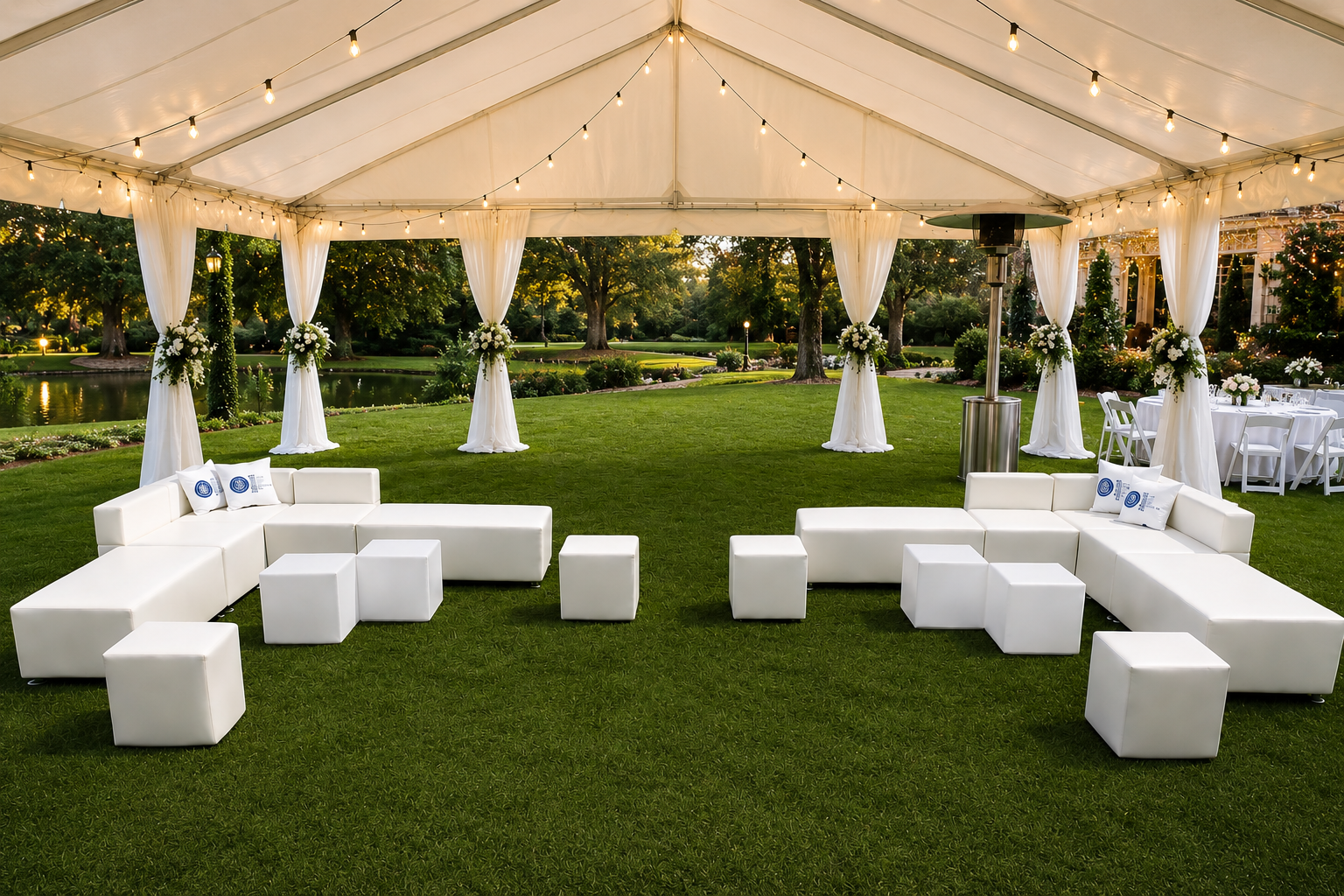 White modular lounge sets under a string-lit event tent